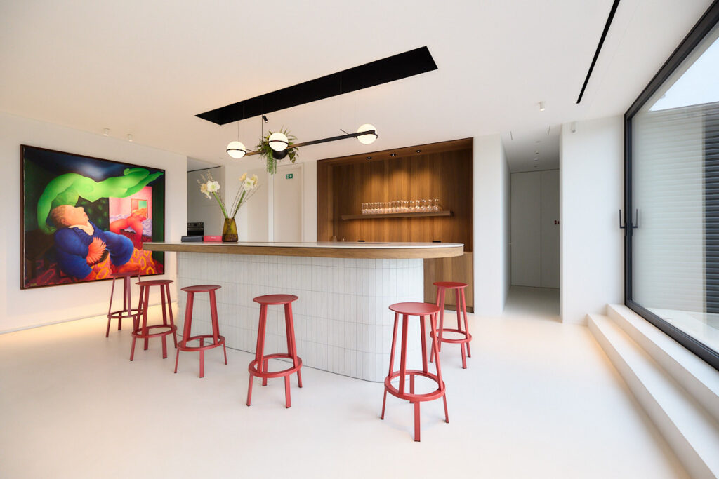 Modern spanplafond met geïntegreerde verlichting in een stijlvolle ontvangstruimte met bar en minimalistisch interieur.