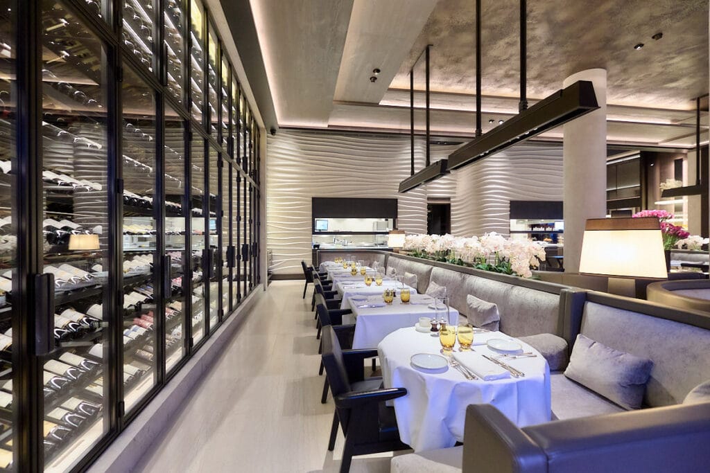Luxe restaurant met een naadloos spanplafond, geïntegreerde ledverlichting en stijlvolle wijnwand.