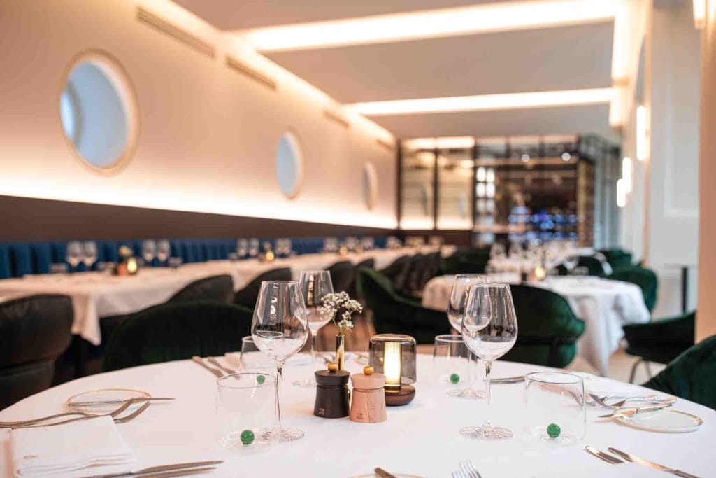 Naadloos wit spanplafond met geïntegreerde LED-lijnen in het restaurant Belga Queen, gerealiseerd door MonaVisa.