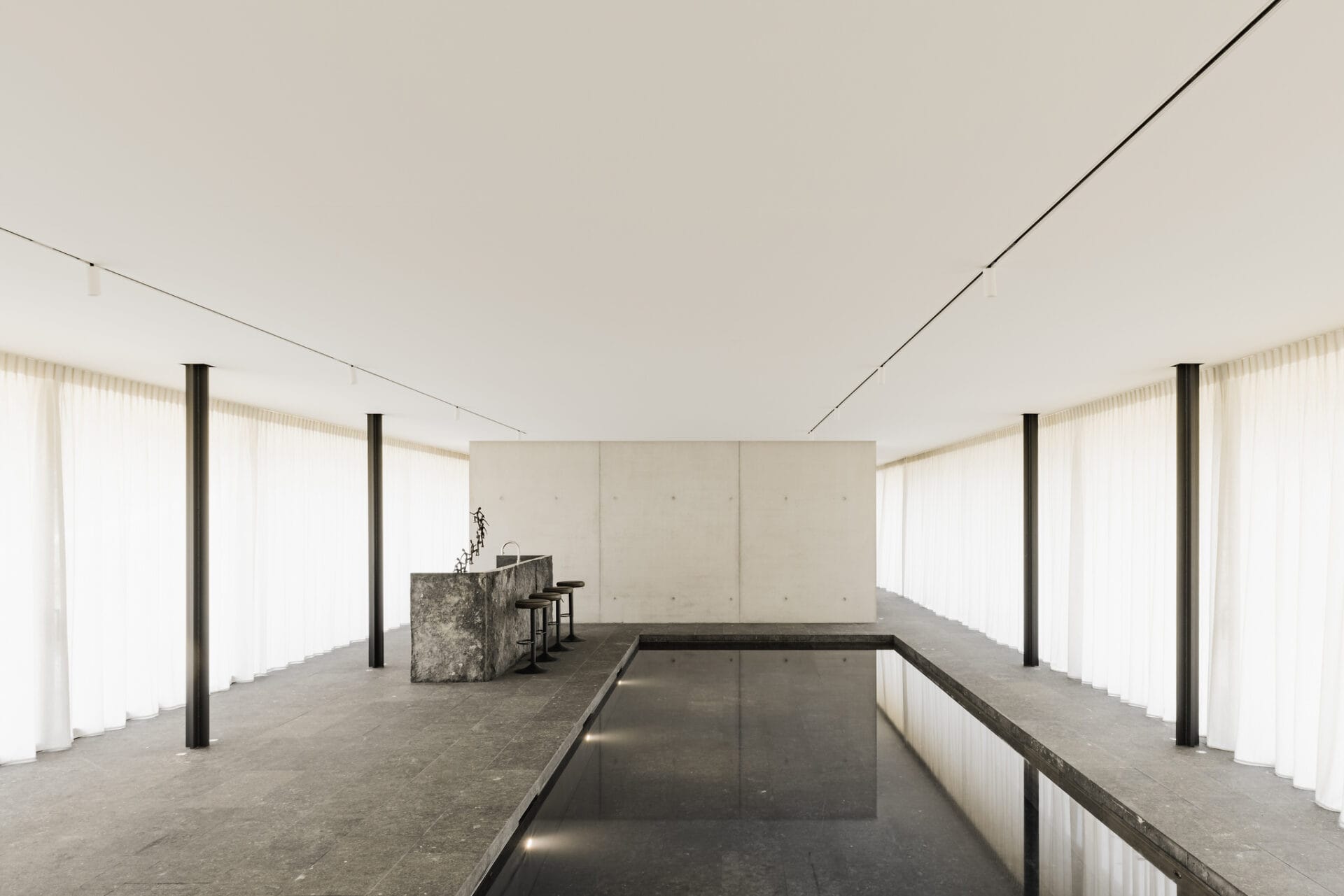 Naadloos polyester spanplafond met geïntegreerde railverlichting in een exclusieve moderne woning.